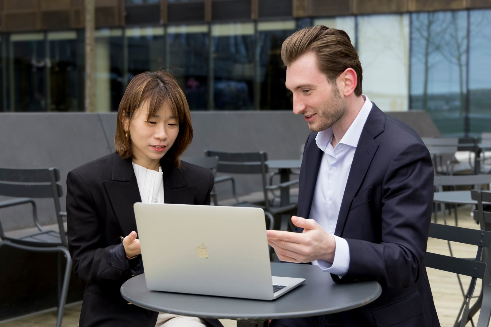 Two professionals reviewing a laptop together during a work meeting